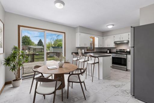 Freshly painted cabinets, walls, and ceiling. Bright and clean kitchen featuring white cabinetry, new stainless steel appliances, and new flooring. The breakfast bar adds additional seating and a functional workspace for everyday living.
