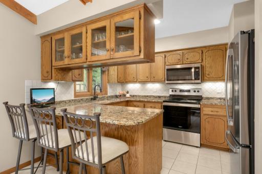 Updated kitchen with granite counters, tile backsplash, and new stainless-steel appliances (2023)