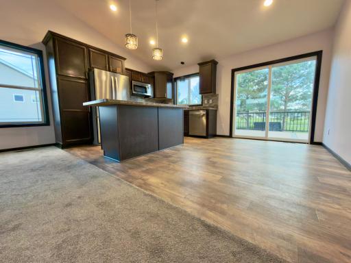 Kitchen with eat up island counter and dining with patio doors.