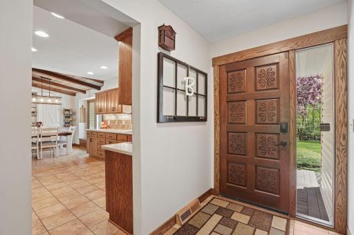 Grand, welcoming foyer makes a memorable first impression with a decorative solid wood entry door, elegant side window, and flows effortlessly into the kitchen.