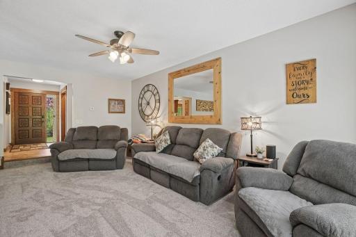 Luxurious sunken living room designed for both comfort and entertaining, featuring alighted ceiling fan, ultra-plush carpeting, and expansive space for oversized furnishings