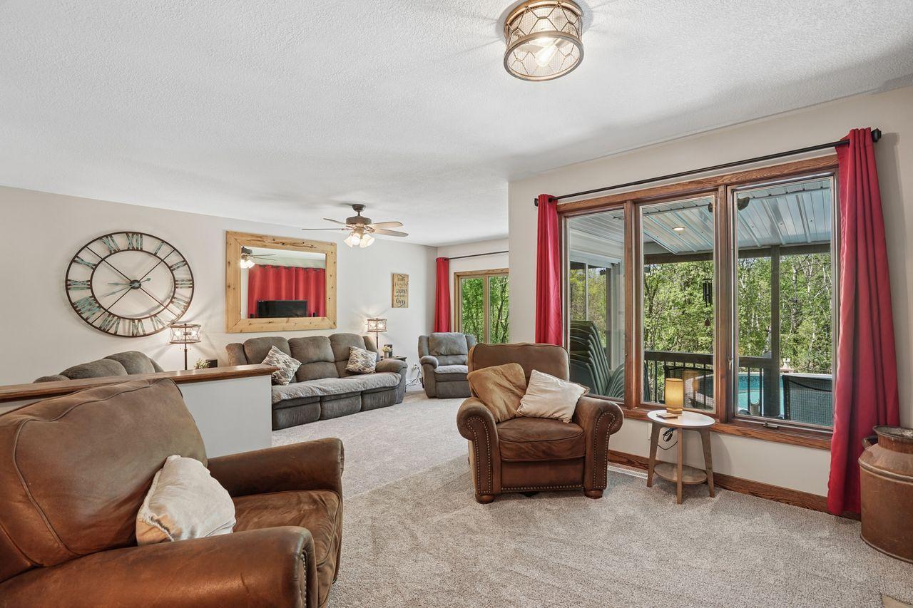 Stunning sitting room seamlessly opens to both the living and dining rooms, creating an inviting flow with beautiful views overlooking the sparkling above-ground pool.