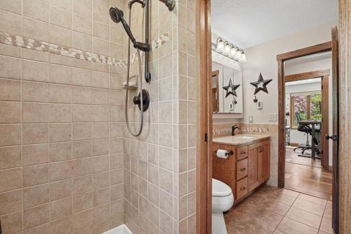Private primary tiled shower and sink separated by a discreet pocket door.