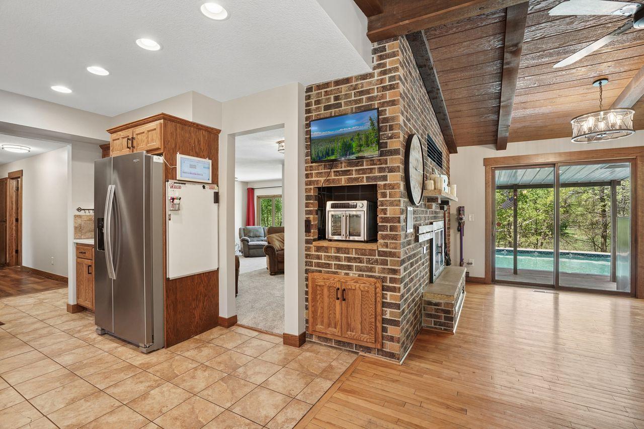 Thoughtful details throughout add both charm and functionality, including additional built-in storage cabinetry and a convenient appliance nook cleverly integrated into the side of the stunning brick fireplace surround