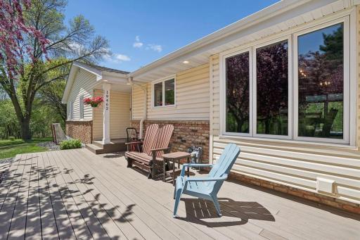 Welcoming front deck with picturesque views of the lush yard and blooming trees.