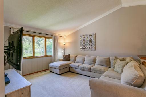 Living room with vaulted ceiling, crown molding and open rail to main level