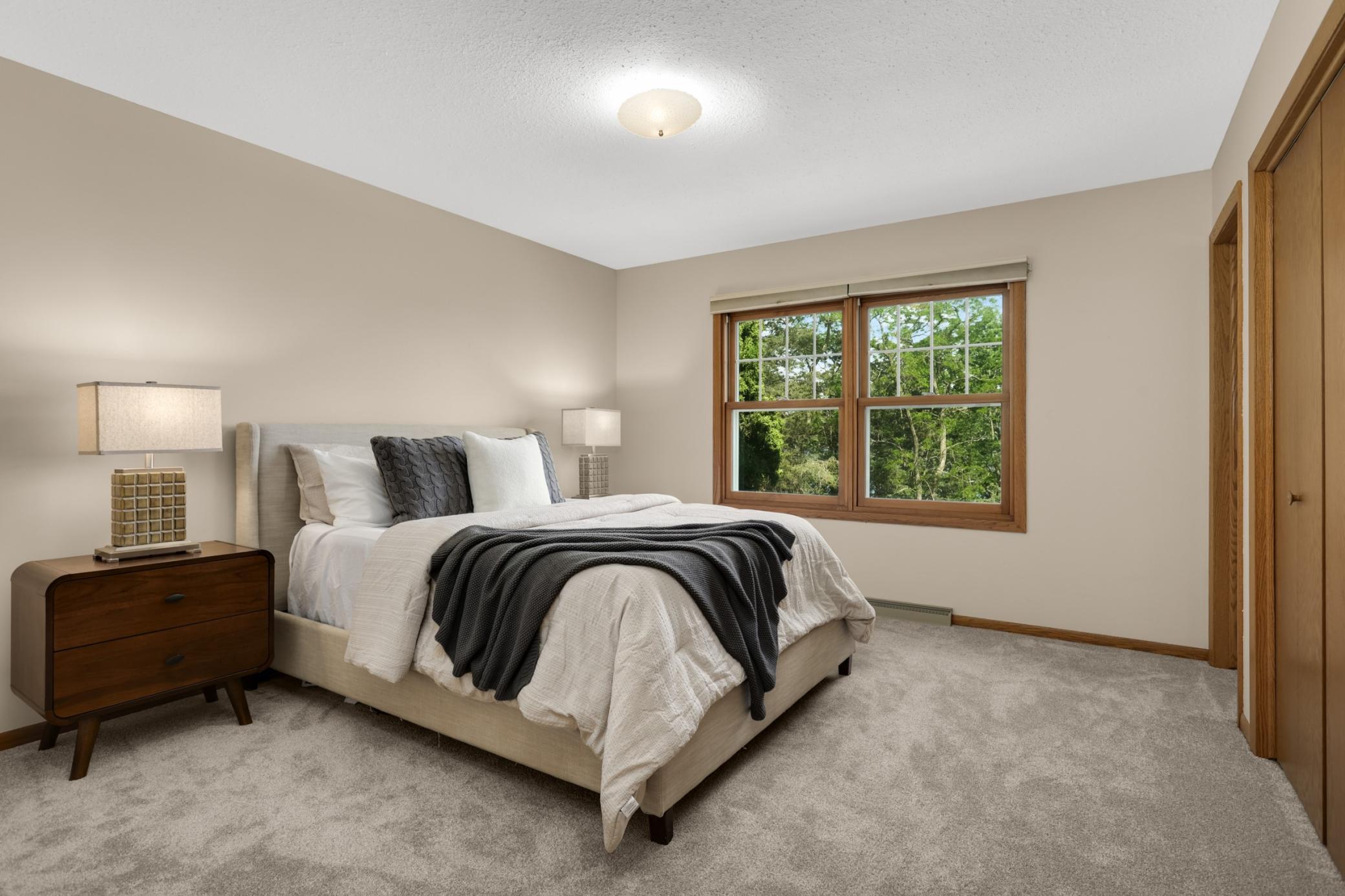 Main level primary bedroom with new carpeting.