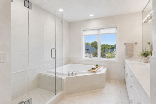 Virtual wallpaper removal and staged Primary Bedroom. A spa-inspired primary bath with sleek new frameless glass shower and relaxing jetted tub.