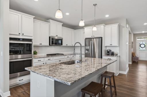 Crisp white cabinetry kitchen with granite countertops with a white tiled back splash. All stainless steel appliances are included. Don't miss the walk-in pantry in the hallway for even more kitchen storage space!