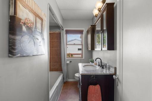 Main level full bath with vanity with granite countertop