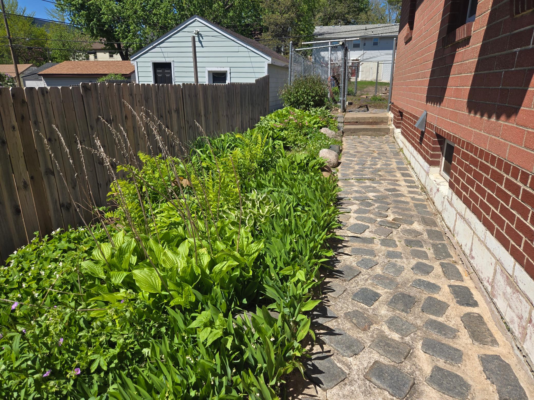 Tons of perennial gardens along the paver walk way and in the front.