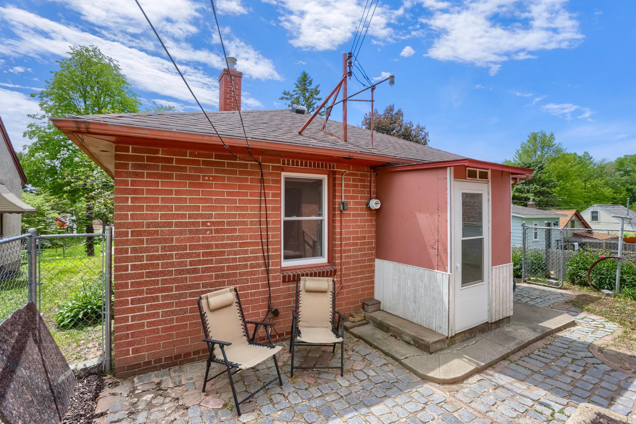 The rear paver patio is between the garage and the house and has a nice area to plant a garden.