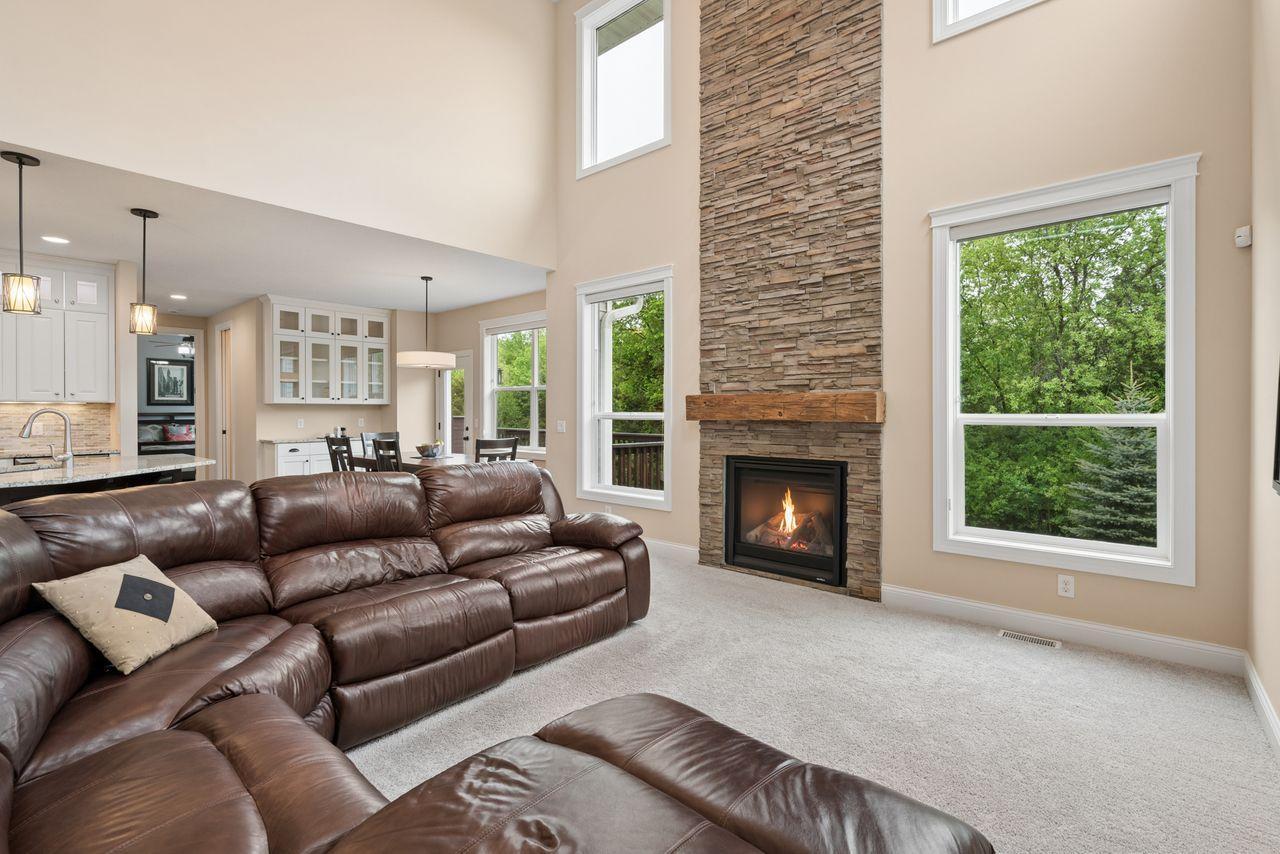 Grand two-story living room with a gorgeous fireplace that anchors this open concept floor plan.