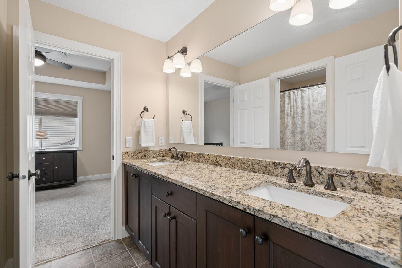 Jack and Jill bathroom adjoining two upper-level bedrooms. Double vanity with a pocket door to the tub/shower.