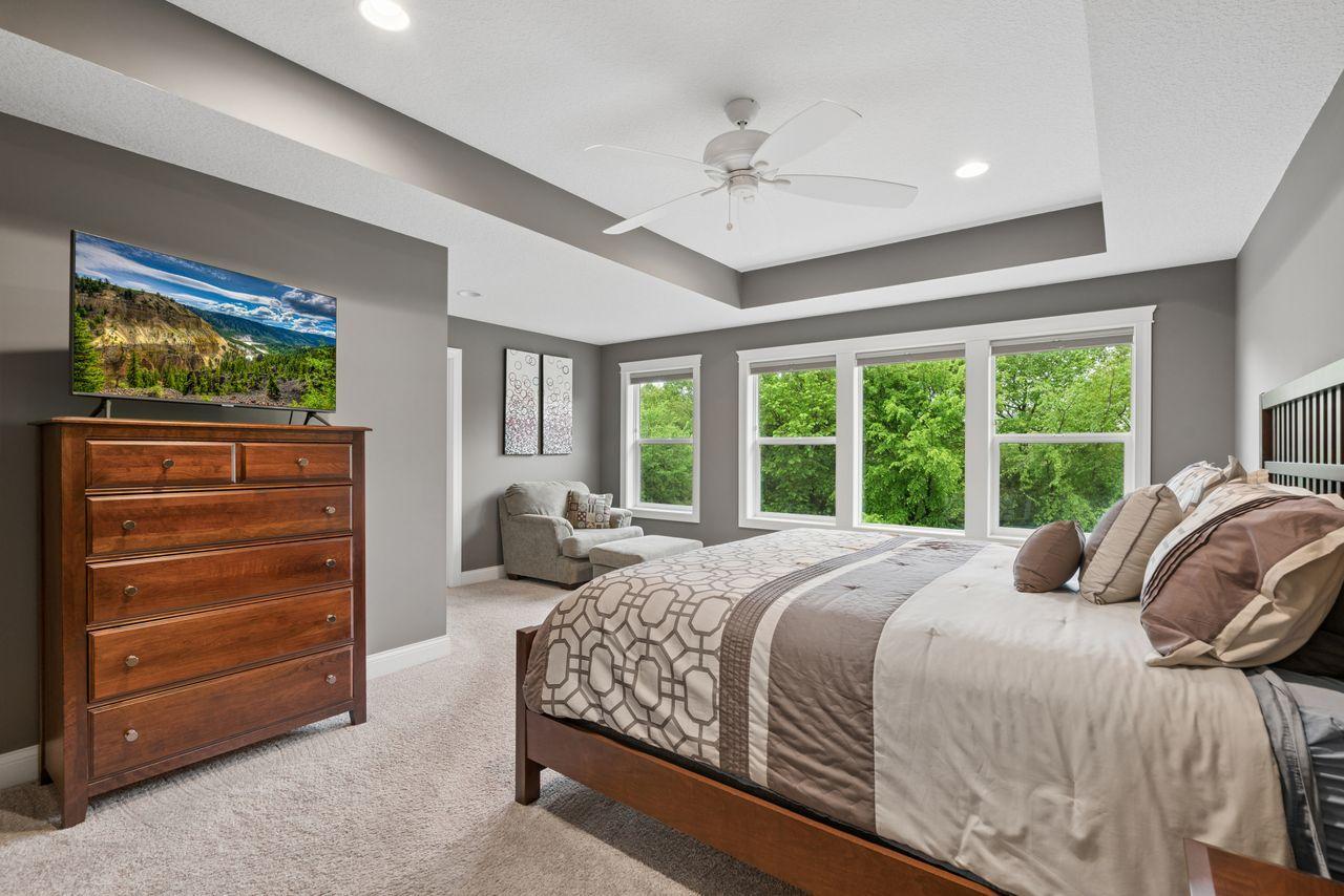 This primary suite is impressive complete with expansive windows to view the backyard, siting area, and tray ceilings.