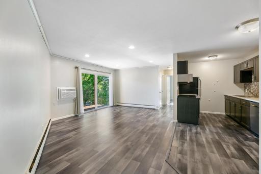 Open concept living, dining, kitchen with updating flooring throughout