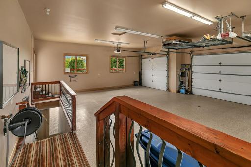 Functional stair access from the garage seamlessly connects to lower-level living spaces. Garage has floor drains with drainable catch basins below. Stairs shown here also access the lower level garage space.