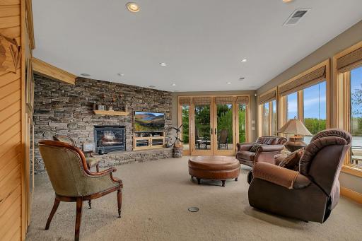 Lower level family room with another stone fireplace creating a warm focal point.