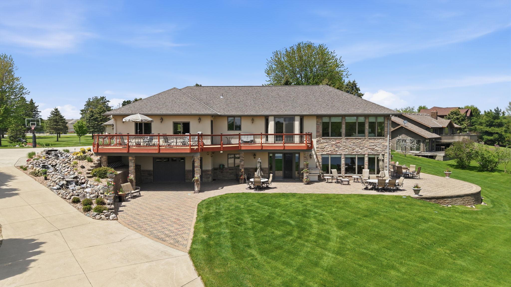 Drone depiction of the extra driveway, tuck under, full hardscape, fountain and the large deck.