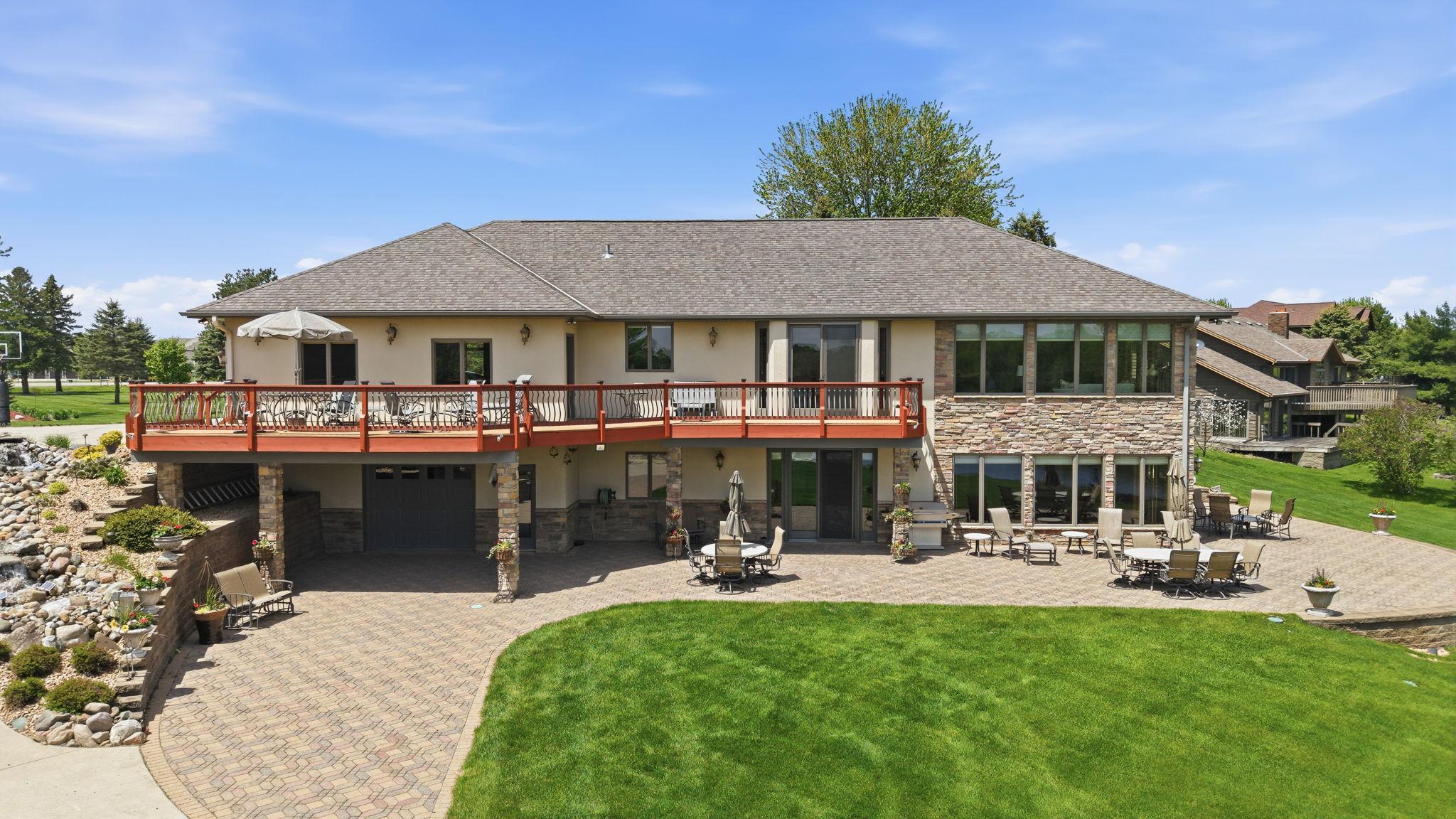 View of the back of the home. Hardscapes create function for entertaining. Perfectly complimented by a lush yard for playing.