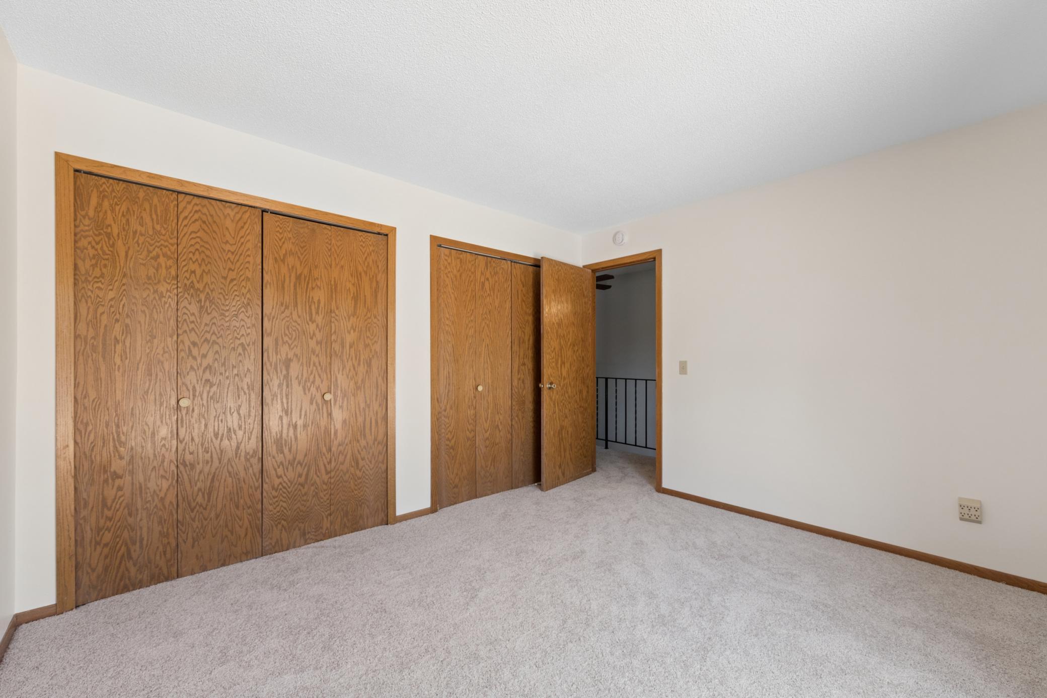 Secondary bedroom with dual bi-fold closets, new carpet and paint throughout (2026).