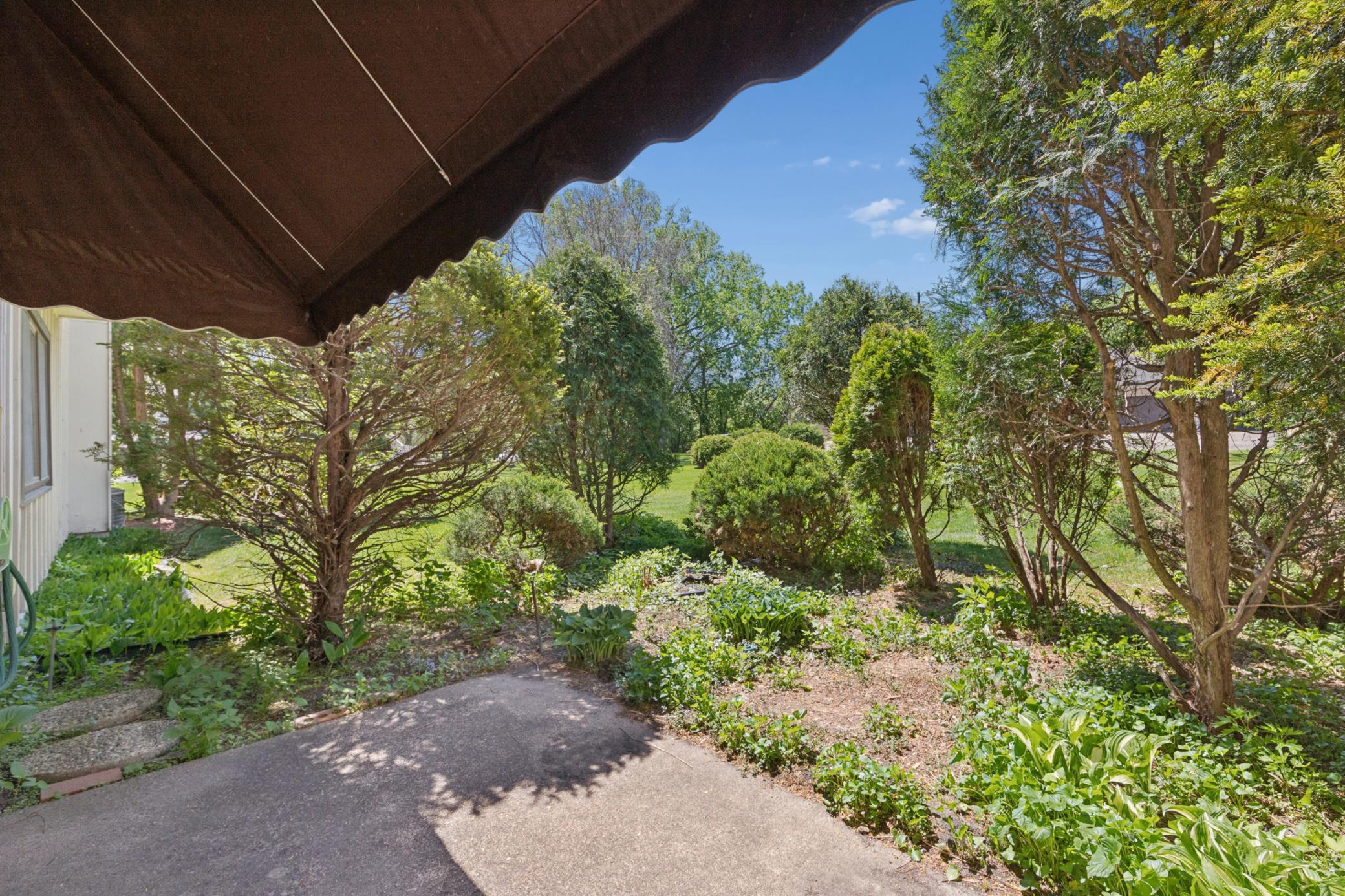 Back yard off of main level living room, cute private space for personal landscaping, nice patio with sunshade.