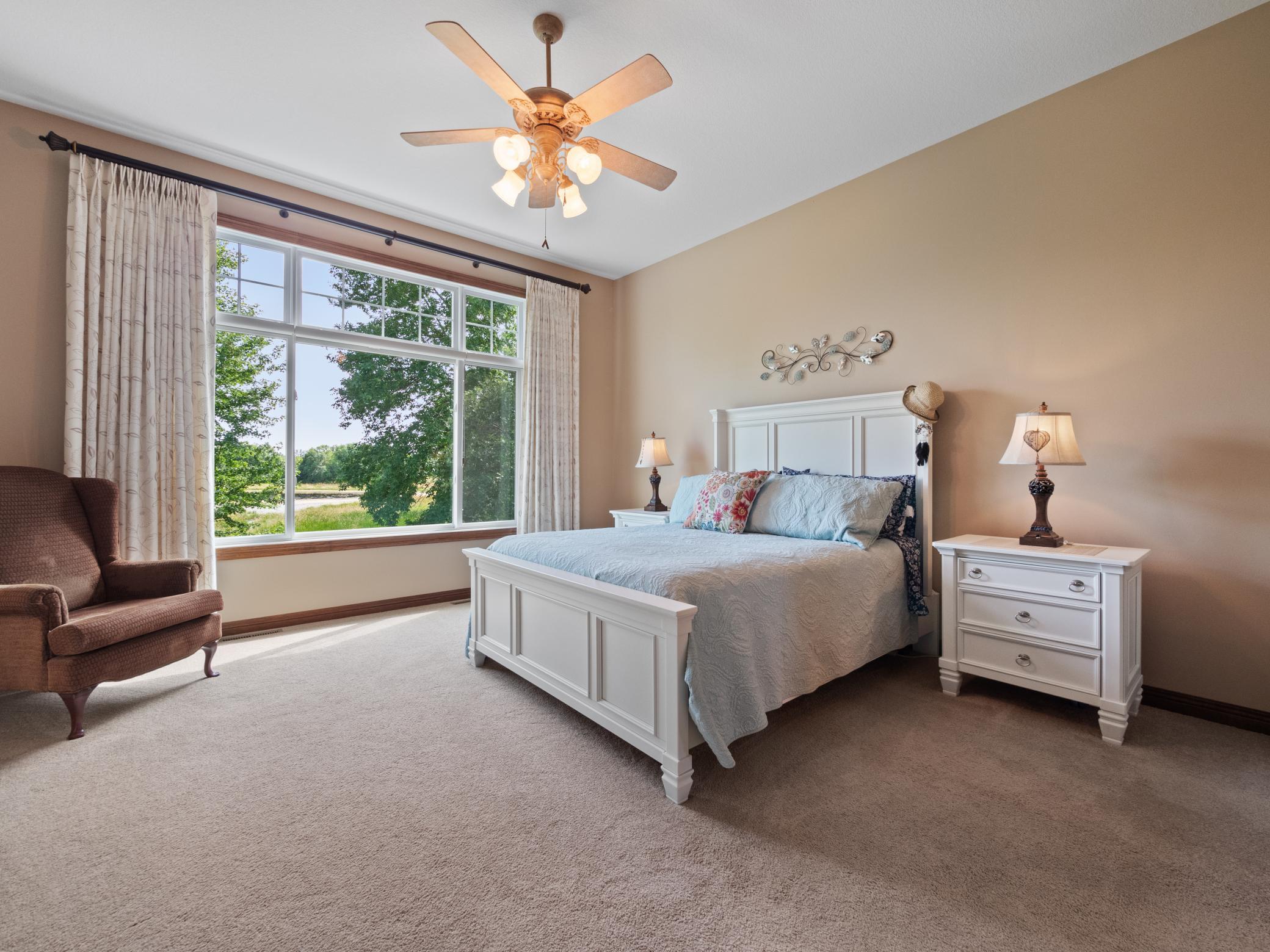 The primary bedroom oasis is spacious and delivers neutral colors, tons of natural light and a ceiling fan. Reset each day with peaceful views out the large windows.