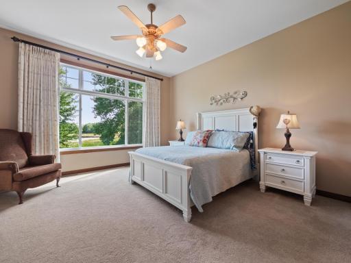 The primary bedroom oasis is spacious and delivers neutral colors, tons of natural light and a ceiling fan. Reset each day with peaceful views out the large windows.