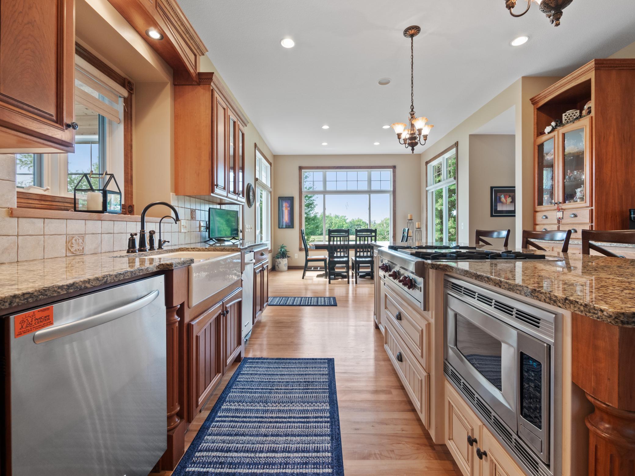 A close-up view of the kitchen, showcasing stainless steel appliances, a farmhouse sink and a well-organized kitchen island with a built-in microwave and stove.