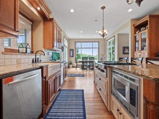A close-up view of the kitchen, showcasing stainless steel appliances, a farmhouse sink and a well-organized kitchen island with a built-in microwave and stove.