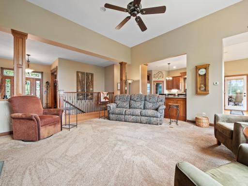 The living room features soaring ceilings, a neutral palette and ceiling fan for added comfort.