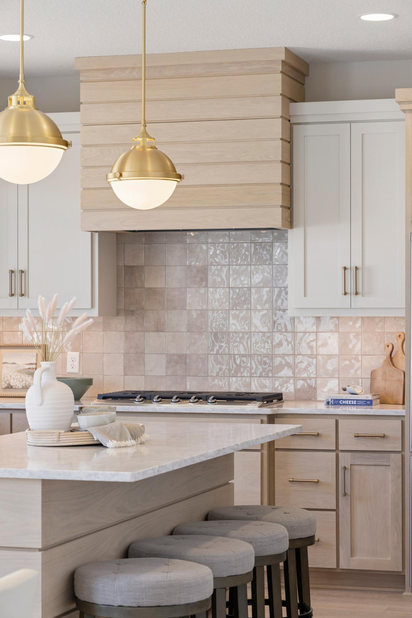 Kitchen features white oak plank range hood and center island.