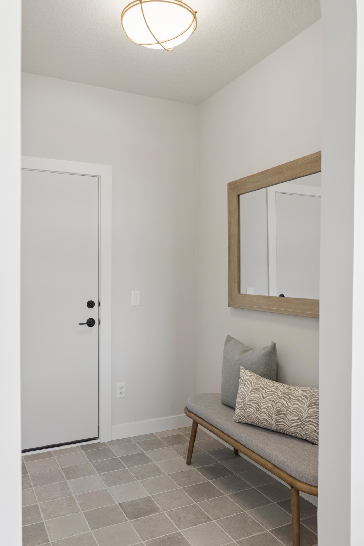 Mudroom off three car garage features walk-in coat closet and stunning tile.