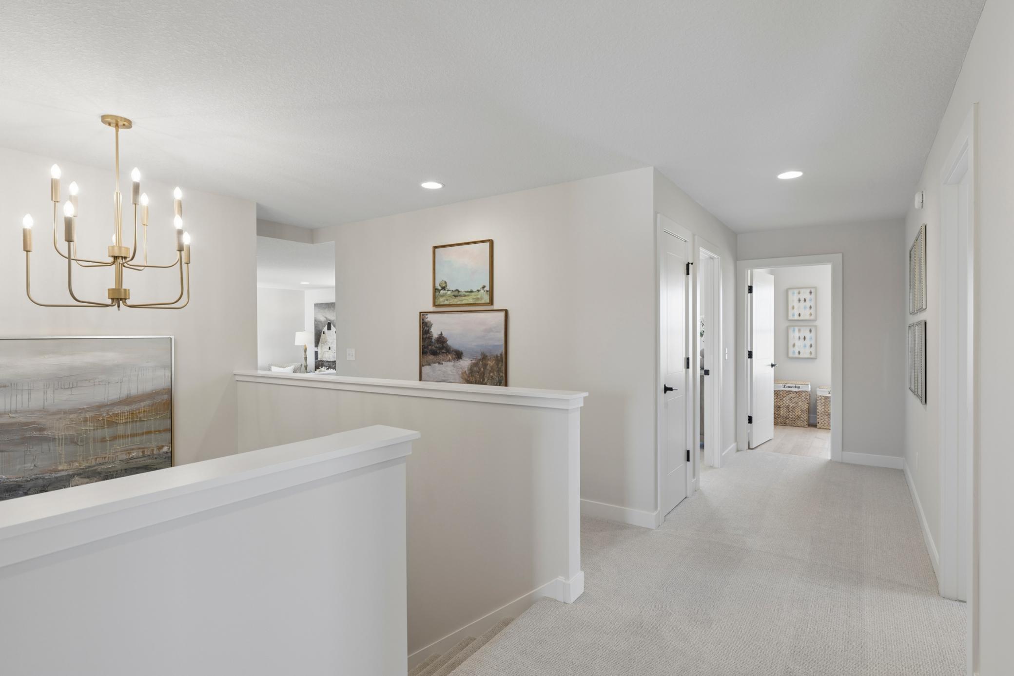 Large landing at top of stairs to upper level with gorgeous hanging light fixture.