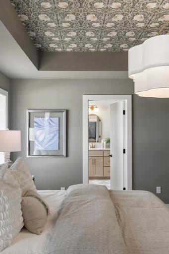 Dramatic vaulted ceiling of primary bedroom along with hanging light.