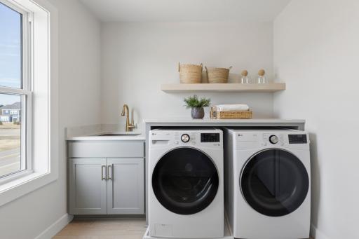 Convenient second floor laundry with custom cabinets and quartz countertops plus oak floating shelf.