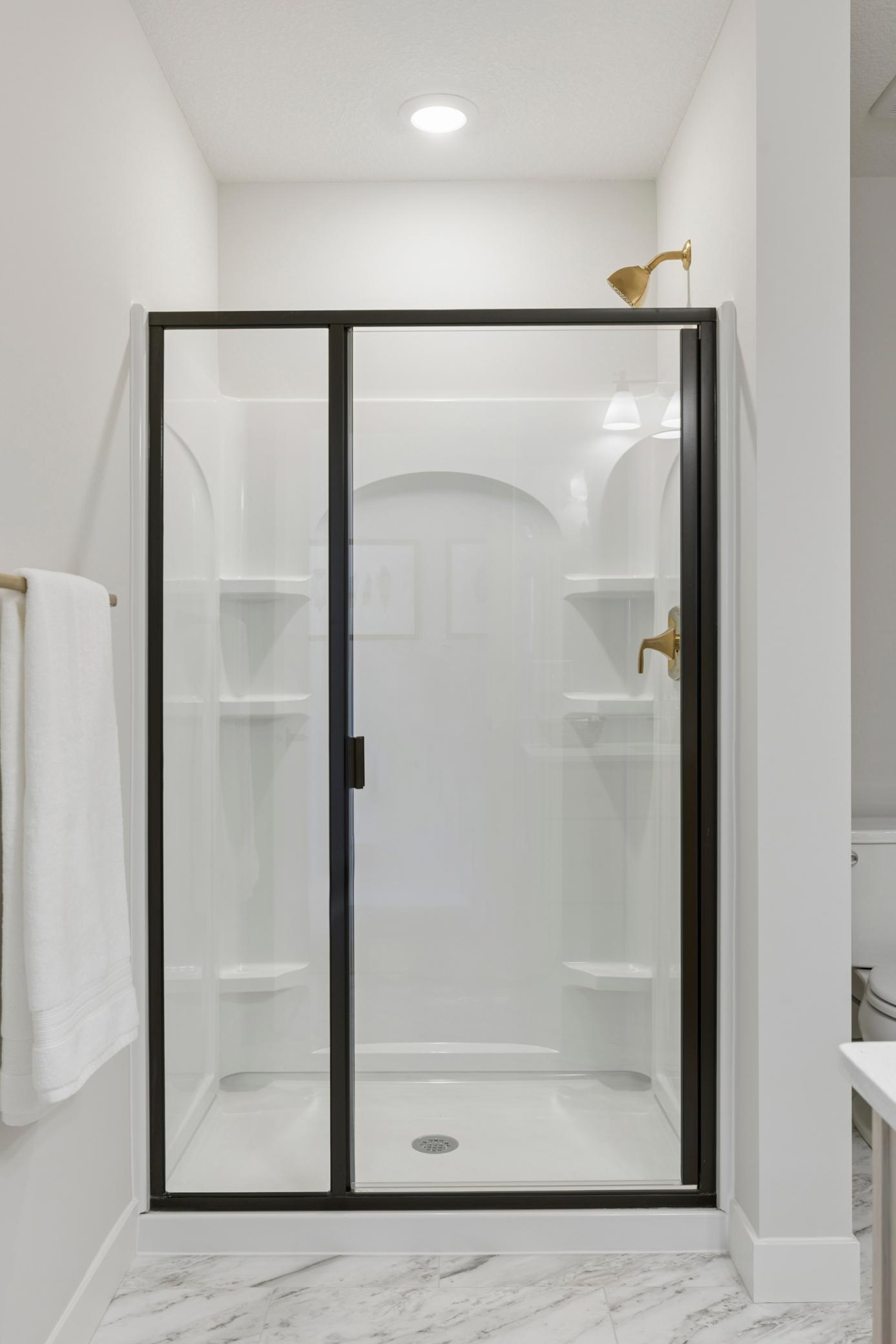 Lower level bath features LVT flooring and large shower.