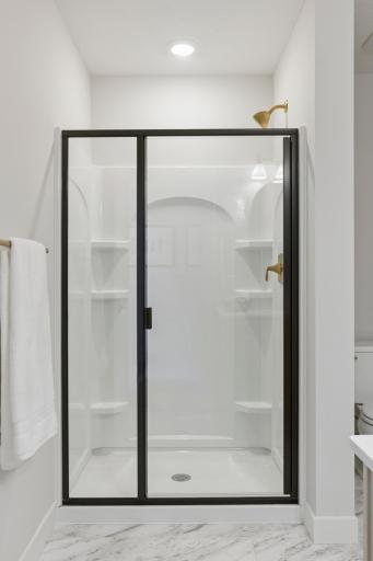 Lower level bath features LVT flooring and large shower.