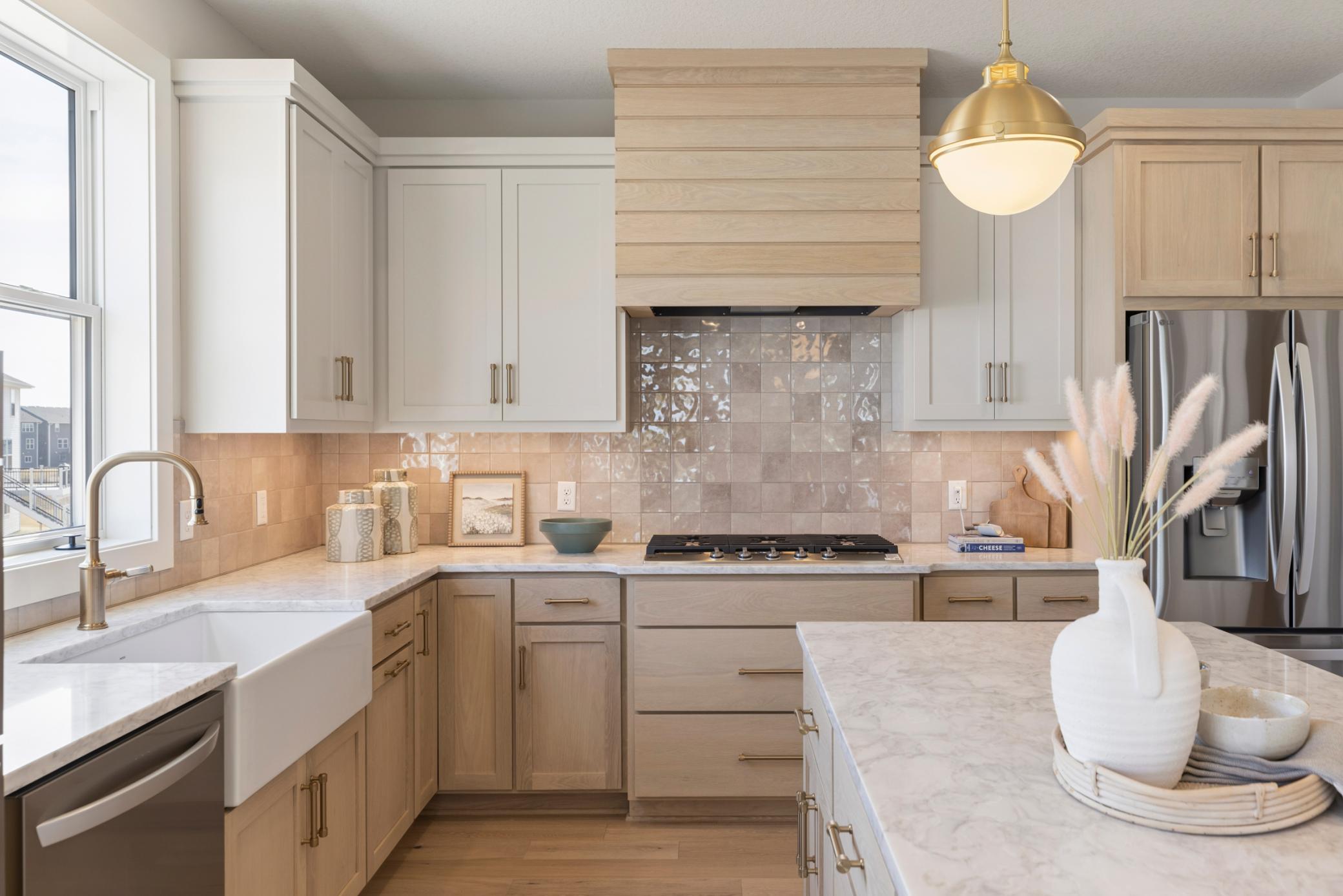 Large fireclay kitchen sink surrounded by beautiful quartz countertops.