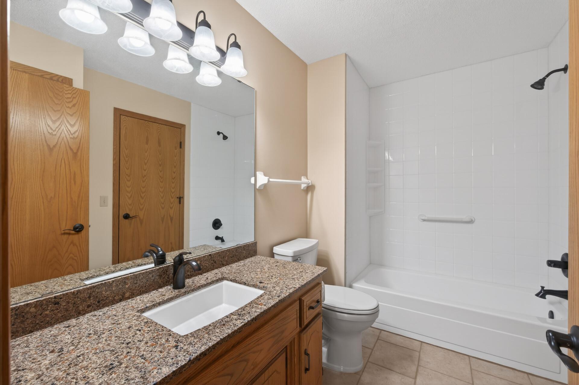 Updated main bath with ceramic tile floor, granite tops, fixtures