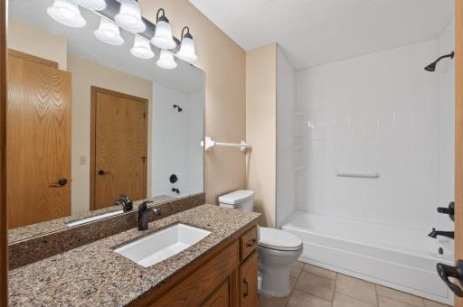 Updated main bath with ceramic tile floor, granite tops, fixtures