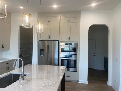 Gourmet kitchen highlights Bosch fridge, built-in microwave and wall oven, plus an elegant arched entry to the mudroomâstyle and function seamlessly combined.
