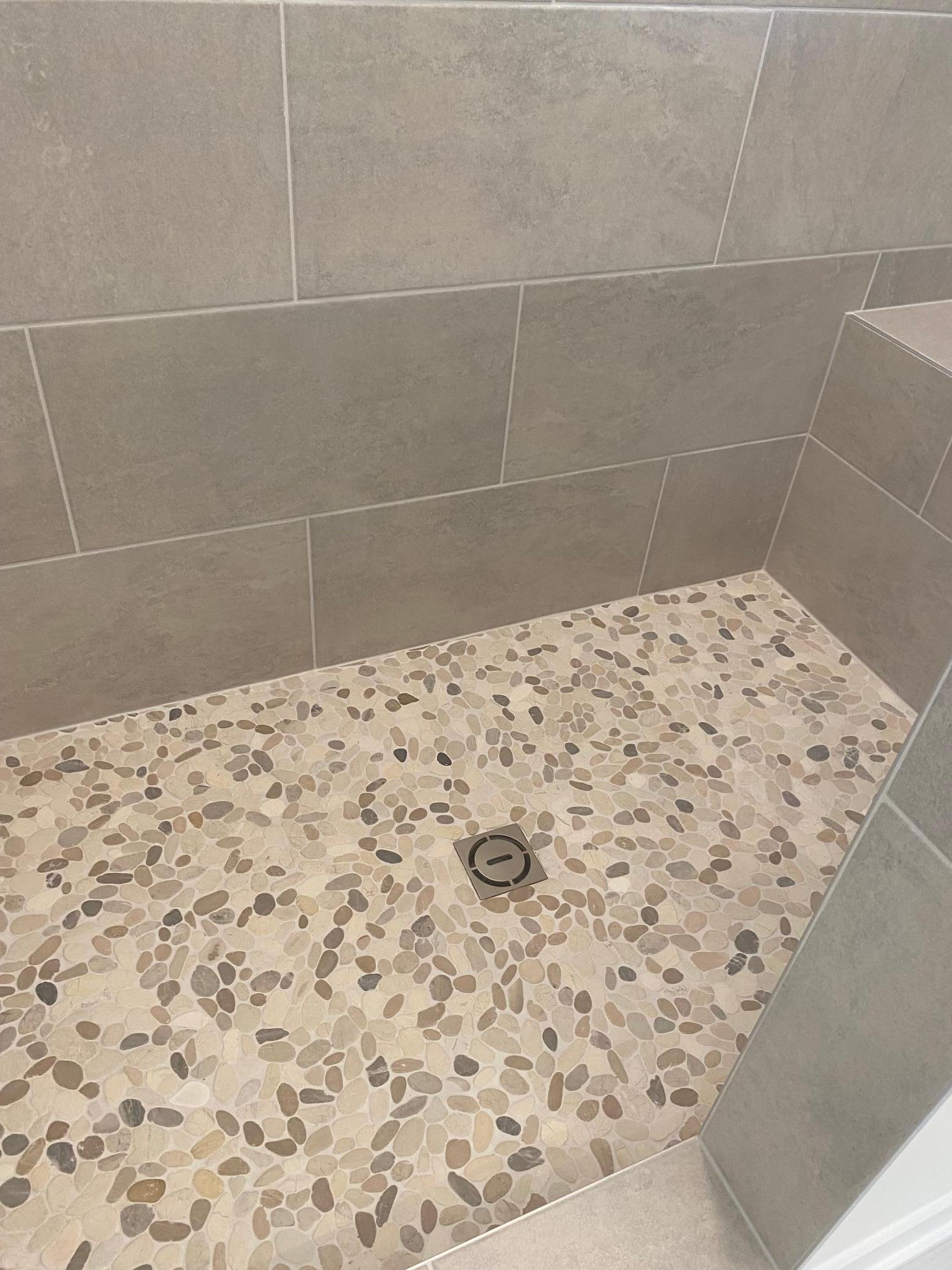 Custom tiled shower floor adds a touch of luxury and style to your daily routine.