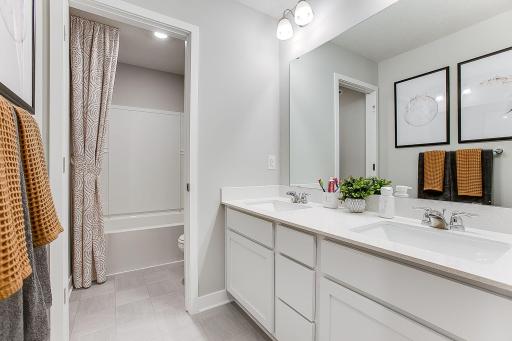 The upper-level hall bathroom also features 2 sinks with Quartz counters and separate tub/shower and toilet area. *Model home, colors and finishes will vary.