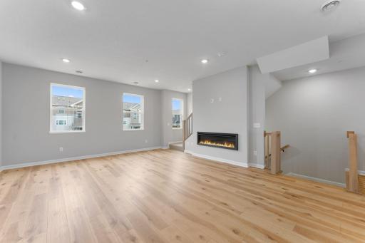 Accented by the warmth of the floors, high ceilings, and large windows, and modern electric fireplace, the family room is a great place to gather! Similar home shown, options can vary.