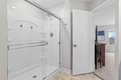 Spacious Primary Suite w/ double door entry, oversized shower, quartz counters + large walk-in closet