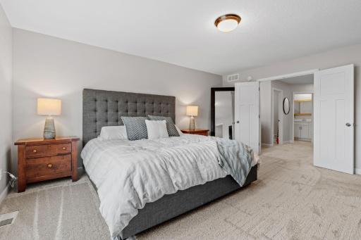 Spacious Primary Suite w/ double door entry, oversized shower, quartz counters + large walk-in closet