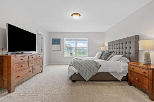 Spacious Primary Suite w/ double door entry, oversized shower, quartz counters + large walk-in closet