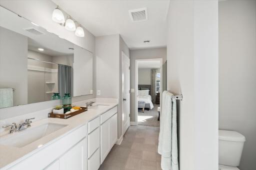 An extension of the primary suite, this private and spacious bathroom contains a double-vanity, linen closet, a stand-in shower and plenty of counter and cabinet space! Photo of model, colors & options will vary.