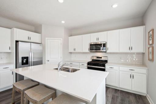 Smart & useful, kitchen is one of performance & boasts a set up which includes a stainless gas range, dishwasher & vented microwave - quartz counters, complimented by modern/clean look cabinets & much more! Photo of model, colors & options will vary